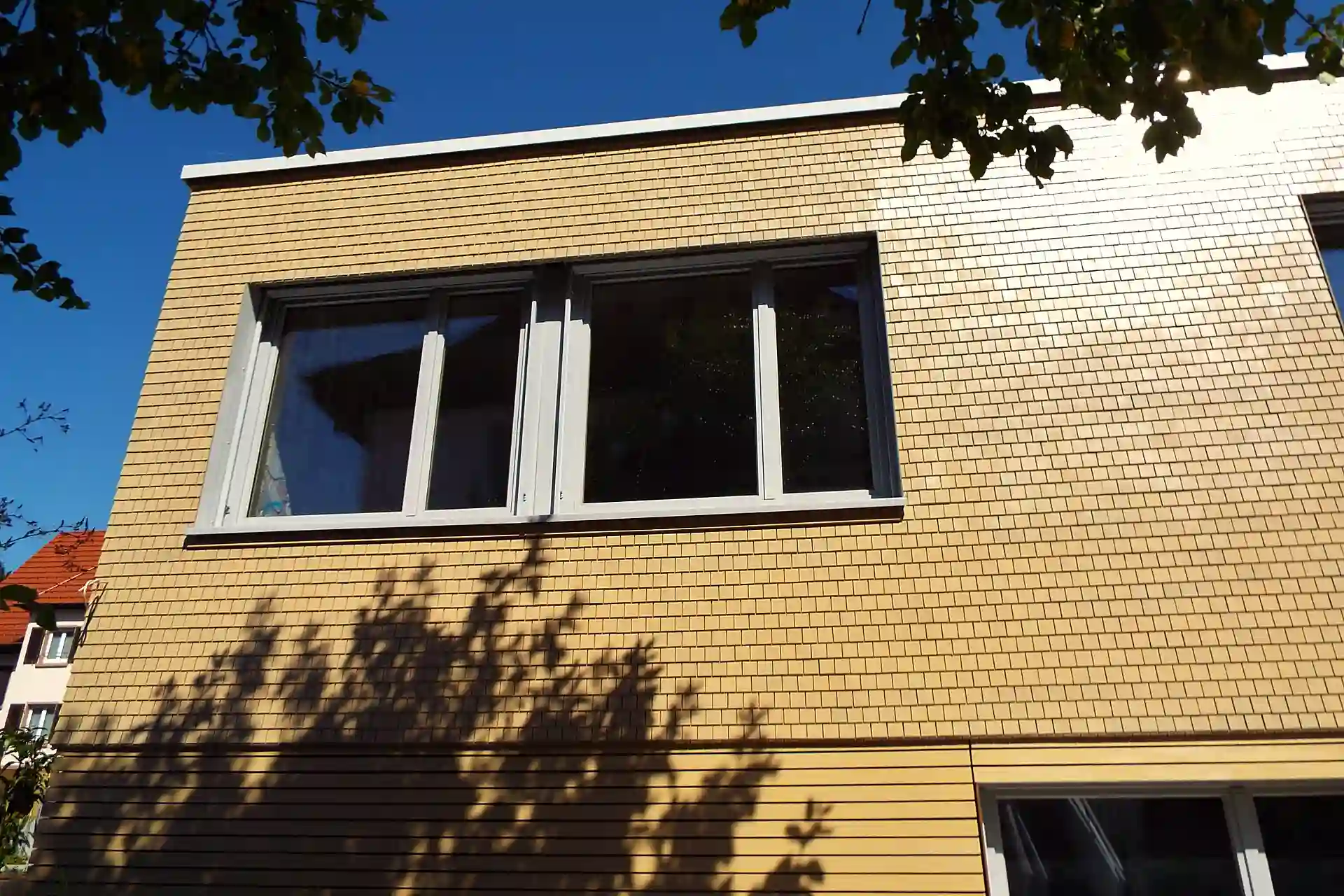 Holzschindeln an einer Fassade eines modernen Gebäudes